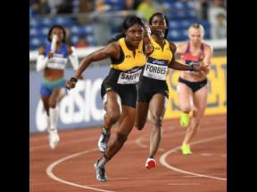 Jonielle Smith (left) receives the baton from Shashalee Forbes in the women’s 4x100-metre relay heats at the 2021  World Athletics Relays in Yokohama, Japan.