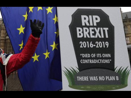 An anti-Brexit demonstrator waves to traffic alongside a banner tied to railings outside parliament in London yesterday. The European Union’s chief Brexit negotiator, Michel Barnier, is rejecting the possibility of putting a time limit on the ‘backstop’ option for the Irish border, saying it would defeat the purpose. 