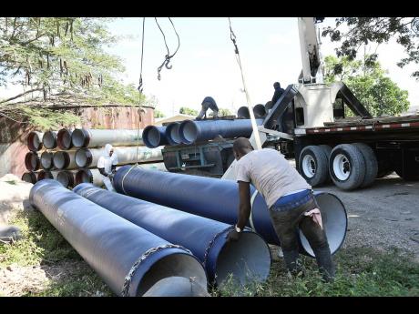 Workmen unloading 18-inch water pipes at the National Water Commission Ferry water supply system in St Andrew recently. They are to replace the old transmission pipelines from Ferry to Six Miles in St Andrew. 