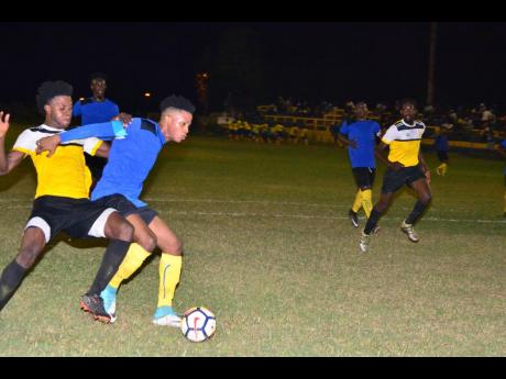 Tevoy Colespring (second left) of Meadforest FC holds off Barbican FC’s Damian English during their Magnum KSAFA Super League first-round clash at Constant Spring Complex. Barbican won 1-0.