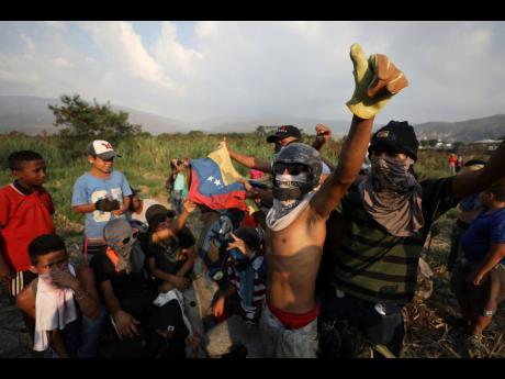 Venezuelan migrants near the Simón Bolívar International Bridge plead for people to support them with food and water so they can continue protesting in La Parada near Cucuta, Colombia, on Sunday, on the border with Venezuela. A US-backed drive to deliver foreign aid to Venezuela on Saturday met strong resistance, as troops loyal to President Nicolás Maduro blocked the convoys at the border and fired tear gas on protesters. 