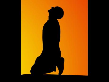 Silhouette of man near the grave at sunset