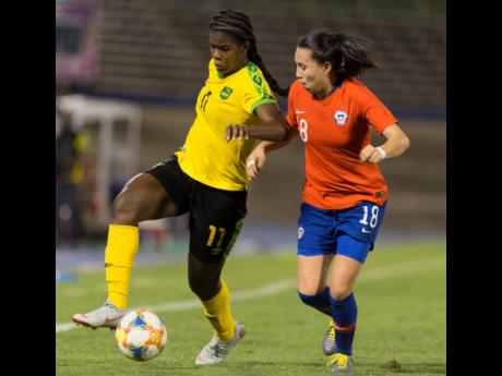 Jamaica’s striker Khadija Shaw (left) dribbles the ball downfield, while being pressured by Chile’s Camila Sáez during their international friendly held at the National Stadium last Thursday. Jamaica won 1-0.