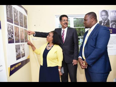 President of the University of Technology (UTech) Professor Stephen Vasciannie (centre) and Campus Registrar Mercedes Deane (left) show senior advisor to the state minister for education, youth and information Howard Chamberlain a photograph at the official opening of the institution’s 60th anniversary exhibition on March 4. 