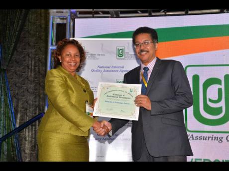 Credit: Albert Ferguson Professor Stephen Vasciannie, president of the University of Technology Jamaica, collecting his Institutional accreditation certificate from Dr. Carolyn Hayle, chairman of the University Council of Jamaica (UCJ). The certificate was handed over at the just-concluded UCJ symposium on quality assurance in higher education in Montego Bay.
