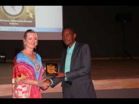 Credit: Chairman of the Hanover Charities foundation, Kathrin Casserly, presents an award plaque to Constable A. Sinclair of the Sandy Bay Police Station for outstanding service to the community. Constable Sinclair is also the Hanover LASCO Top Cop for 2018.