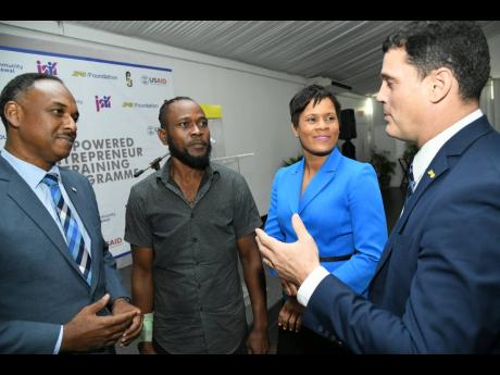 Credit: Rudolph Brown Kevon McLeish (second left), Majesty Gardens entrepreneur, converses with from left Omar Sweeney, managing director of the Jamaica Social Investment Fund; Gillian Hyde, general manager of JN Small Business Loans; and Emanuel DaRosa, president and CEO of the Jamaica Public Service at the Empowered Entrepreneur Training Programme – Build Your Business Expo at the Spanish Court Hotel on Wednesday, April 10.
