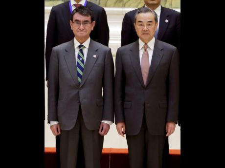 Japanese Foreign Minister Taro Kono (left), and China’s Foreign Minister Wang Yi attend a group photo event before the Japan-China high level economic dialogue at Diaoyutai State Guesthouse in Beijing, China yesterday. 