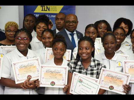 Credit: Contributed Minister of Tourism Edmund Bartlett (centre, back row), and Executive Director of the Tourism Product Development Company (TPDCo) Dr Andrew Spencer (fourth left, back row) with several participants in the Jamaica Blue Mountain Coffee Festival Volunteer Training Programme during an awards ceremony at the University of Technology in St Andrew, on Tuesday.