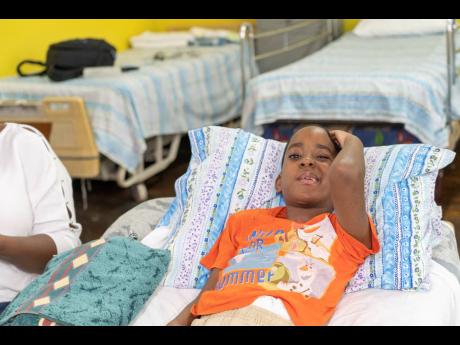 LEFT: Ashane Leslie touches the fragile area, that was impacted when his father’s car  veered into a cement post. Next month, he will undergo surgery to replace the bone fragment.