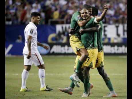 Credit: AP Jamaica’s Rodolph Austin (facing camera) celebrates with teammates Joel McAnuff (left) and Je-Vaughn Watson, as United States’ DeAndre Yedlin walks off the pitch after Jamaica defeated the United States 2-1 in a 2015 Concacaf Gold Cup semi-final on Wednesday, July 22, 2015, in Atlanta.