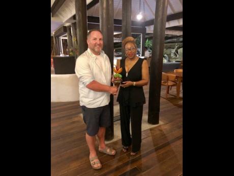 
Jason deCaires Taylor receives his award from the permanent secretary in the Ministry of Tourism and Civil Aviation Arlene Buckmire Outram