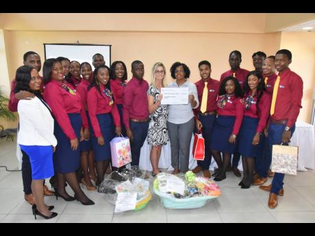 Jan Rygh (centre, left), acting director of the Robin’s Nest Children’s Home in St James, collects a cheque and supplies from Moesha Miller, president of Elite Executive Marketing Professionals, at the Montego Bay Community College last Thursday.