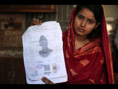 In this April 14, 2019 photo, Mahek Liaqat, who married a Chinese national, shows her marriage certificate in Gujranwala, Pakistan. Poor Pakistani Christian girls are being lured into marriages with Chinese men, whom they are told are Christian and wealthy only to end up trapped in China, married to men who are neither Christian nor well-to-do, and some are unable to return home. (AP Photo/K.M. Chaudary)