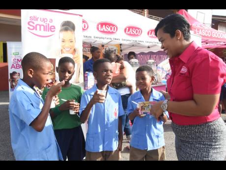 Tameka Singh-Kellier (right), LASCO Distributors’ breakfast brand manager, chats with grade-three St Andrew Preparatory School students about their favourite LASCO breakfast meals during the kick-off of its Read Across Jamaica Day and Education Week of activities on Tuesday, May 7. 