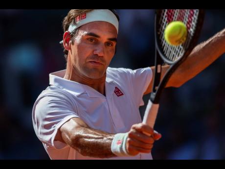 Roger Federer returns the ball to Gael Monfils during the Madrid Open tennis tournament in Madrid, Spain, yesterday. Federer won 6-0, 4-6, 7-6.