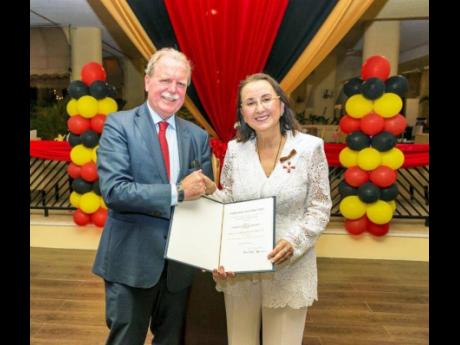 Karolin Troubetzkoy receives the Order of Merit from His Excellency Holger Michael, ambassador of the Federal Republic of Germany to the Caribbean.