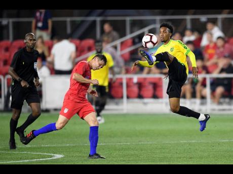 Jamaica midfielder Tyreek Magee (right) acrobatically traps the ball before being challenged by United States midfielder Wil Trapp (middle) during the second half of their international friendly match at Audi Field in Washington DC on Wednesday night. Jamaica won 1-0.  