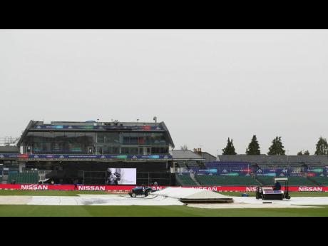 Ground staff work to clear water off the outfield prior to the ICC Cricket World Cup match between Pakistan and Sri Lanka, at Bristol County Ground, in Bristol, England yesterday. 