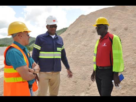 Credit: Contributed Eddie Cousins (left) director of Lydford Mining, and his operations director, Sam Millington (centre), talk with Daniel Brown, senior manager of the mid-market segment of Scotiabank’s corporate and commercial banking, at the site of their mining operations in St Ann. The company became the first exporter of crushed limestone sand to the United States when it shipped 4,800 tons of construction-grade limestone sand to the USVI in 2018.