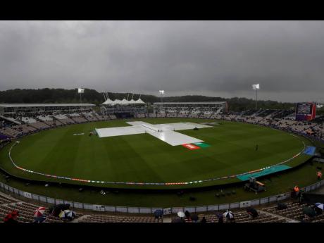 Rain covers on the pitch after play was stopped due to rain during the ICC World Cup match between South Africa and the Windies at The Ageas Bowl in Southampton, England yesterday. (AP Photo/Kirsty Wigglesworth)