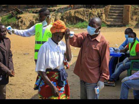 Credit: The Associated Press People crossing the border have their temperature taken to check for symptoms of Ebola, at the border crossing near Kasindi, eastern Congo Wednesday, June 12, 2019, just across from the Ugandan town of Bwera. In Uganda, a 5-year-old boy vomiting blood became the first cross-border victim of Ebola in the current outbreak on Wednesday, while two more people in Uganda tested positive for the highly contagious disease that has killed nearly 1,400 in Congo. (AP Photo/Al-hadji Kudra Maliro)
