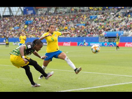 Jamaica’s Trudi Carter (left) whips in a cross before Brazil’s Thaisa can put in a leg to block it during their opening match in Group C of the FIFA Women’s World Cup at the Stade des Alpes in Grenoble, France on Sunday.  