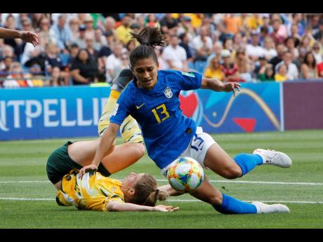 Brazil’s Leticia Santos (right) falls inside the Australian box after being tackled by Australia’s Elise Kellond-Knight during their Group C FIFA Women’s World Cup match at Stade de la Mosson in Montpellier, France, yesterday.  