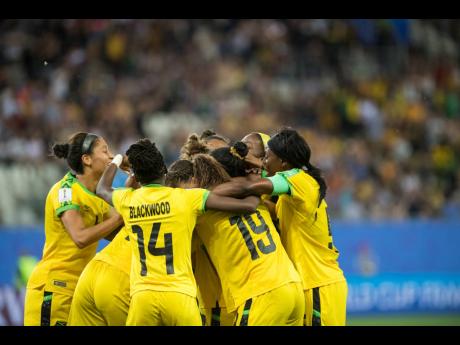 Solaun’s teammates, brimming with elation, rush to congratulate her on scoring Jamaica’s first-ever goal in a FIFA Women’s World Cup match, against Australia yesterday.  