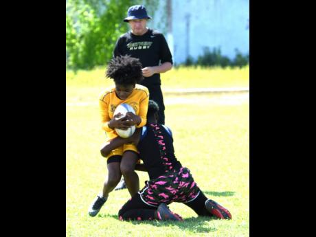 Members of the Jamaica rugby union Lady Crocs team participating in a training session under the watchful eye of coach Stephen Lewis at Emmett Park on Saturday, June 29, 2019.