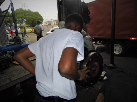 Credit: Contributed Andrew Bent, a ward of the State, examines a motor vehicle engine at a garage where his father works.