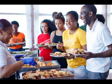Credit: Contributed Chantelle Abratis, Red Stripe Hostess, Kiera Flynn, activation manager at Heineken UK lined up at Gloria’s buffet alongside sweepstakes winners Golda Pearson and Royston Hope.