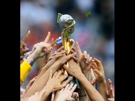 USA players hold the trophy as they celebrate their victory in the FIFA Women’s World Cup final in Decines, outside Lyon, France,  on Sunday, July 7. 
