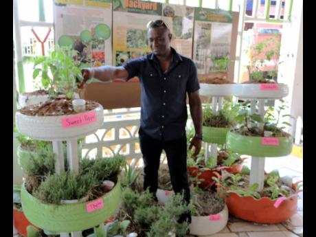 Courtney Taylor, RADA parish manager, poses with the display of used tyres in backyard gardening.