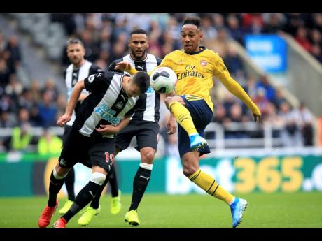 Credit: AP Arsenal’s Pierre-Emerick Aubameyang (right) and Newcastle United’s Javier Manquillo battle for the ball during their English Premier League match at St James’ Park in Newcastle, England, yesterday. Aubameyang scored the only goal in Arsenal’s 1-0 win.