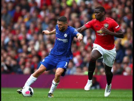 Manchester United’s Paul Pogba (right) challenges Chelsea’s Mateo Kovacic during the English Premier League match at Old Trafford in Manchester, England, yesterday. United won 4-0.