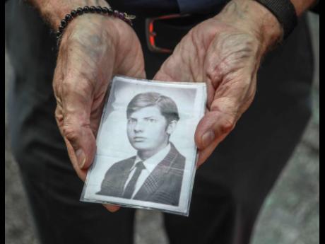 This Wednesday, Aug. 7, 2019 photo shows Brian Toale shows a photo of himself at 16 years old in New York.  Thousands of people who say they were molested as children in New York state will head to court this week to file lawsuits against their alleged abusers and the institutions where they worked.  Toale, 66, who says he was molested by an employee at a Catholic high school he attended on Long Island, was one of the leaders in the fight to pass the Child Victims Act.  (AP Photo/Bebeto Matthews)