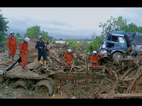 Members of a Myanmar rescue team work at a landslide-hit area in Paung township, Mon State, Myanmar, on Monday.