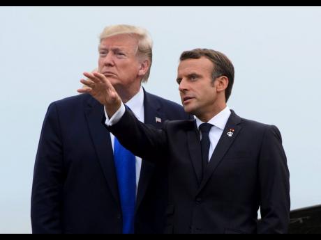 US President Donald Trump (left) is greeted by French President Emmanuel Macron as he arrives to the G7 Summit in Biarritz, France, Saturday. 