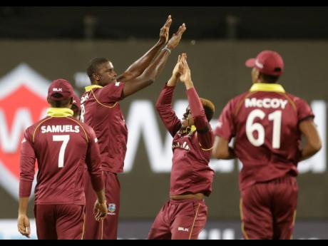 West Indies’ captain Jason Holder (second left) celebrates with teammates the dismissal of India’s Mahendra Singh Dhoni during the third one-day international cricket match between India and West Indies in Pune, India, Saturday, October 27, 2018. 