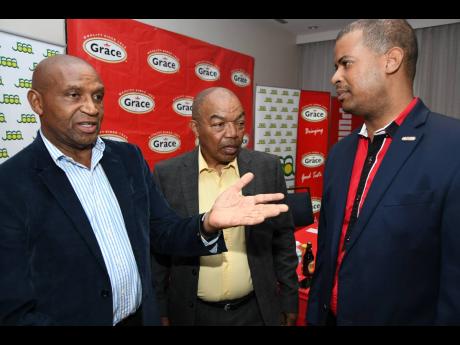 Grace Foods Chief Executive Officer Frank James (right) has a chat with Jamaica Athletics Administrative Association president Dr Warren Blake (centre) and first vice president Ludlow Watts at the body’s press conference to announce the national team to the IAAF World Championships in Doha, Qatar, at the Courtyard by Marriott Hotel in Kingston on Wednesday. 