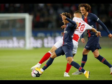Paris Saint-Germain’s (PSG) Neymar (left) fights for the ball with Reims’ Remi Oudin (18) while Adrian Rabiot, then of PSG, looks on during their French Ligue 1 match at the Parc des Princes in Paris, France, last season. 