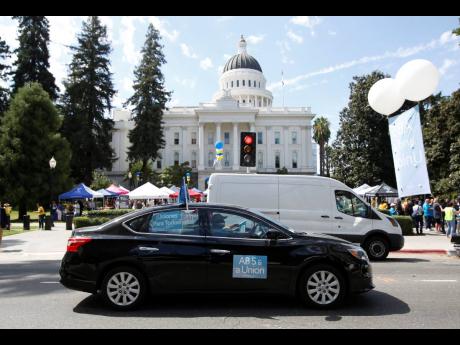 AP 
In this Aug 28, 2019 file photo, dozens of supporters of a measure to limit when companies can label workers as independent contractors circle the Capitol during a rally in Sacramento, California.