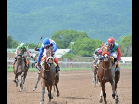 KINGSMAN (right), ridden by Omar Walker, wins last Saturday’s fifth race at Caymanas Park ahead of RAW LIQUID (Chris Mamdeen).  