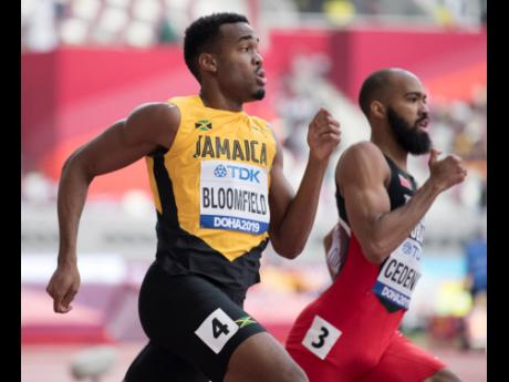 Akeem Bloomfield competing in the men’s 400m heats yesterday. At right is Trinidad and Tobago’s Machel Cedenio who won the heat ahead of Bloomfield.