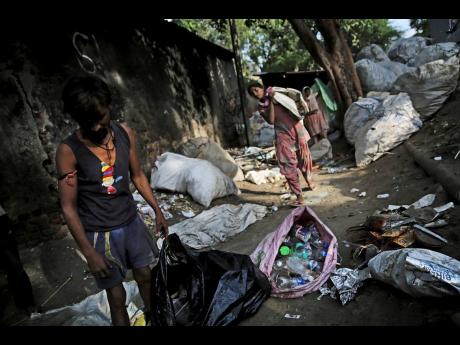 Indian rag-pickers collect plastic bottles in New Delhi, India.  (AP)