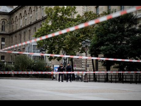 Credit: The Associated Press Police officers stand guard outside the Paris police headquarters on Thursday, October 3, 2019. An employee armed with a knife attacked officers inside the building yesterday, killing at least four before he was fatally shot, a French police union official said.