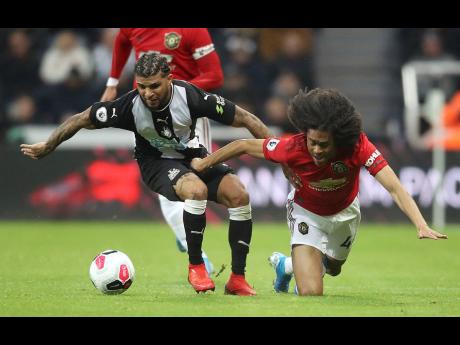Newcastle United’s DeAndre Yedlin (left) and Manchester United’s Tahith Chong battle for the ball during their English Premier League game at 
St James’ Park, Newcastle, England, yesterday.