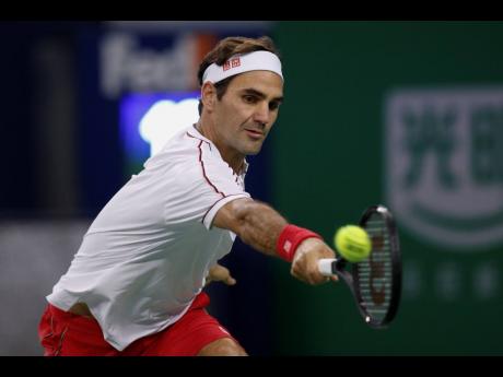 Credit: Andy Wong Roger Federer hits a return shot against David Goffin.