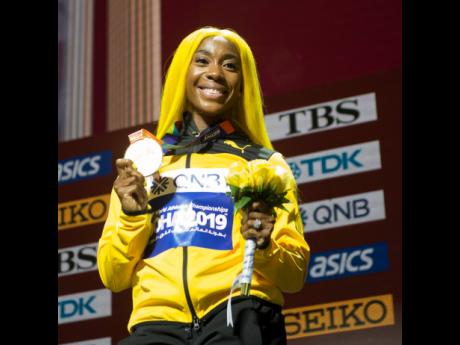 Credit: Gladstone Taylor World 100 metres champion Shelly-Ann Fraser-Pryce with her gold medal after the presentation ceremony at the Khalifa International Stadium in Doha, Qatar.
